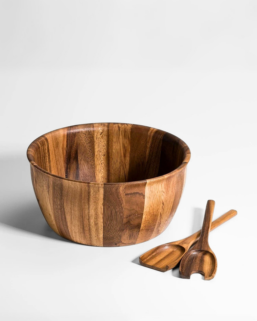 Minimal acacia wood serving bowl with two serving spoons on a white surface